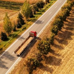 Truck on the road through countryside, aerial view