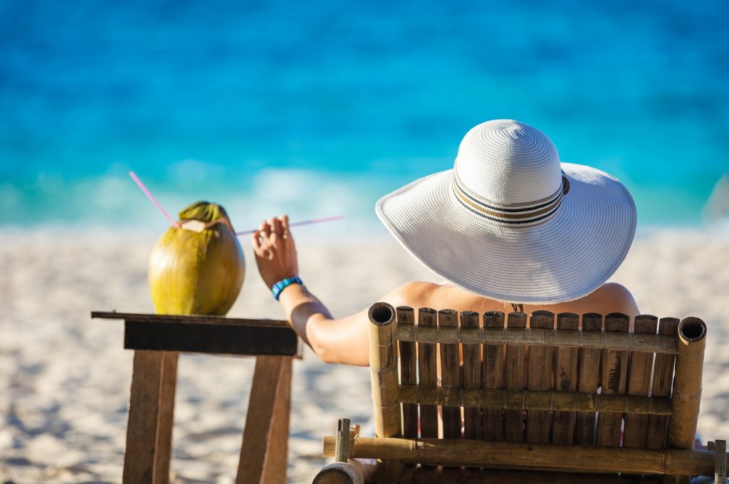 young-woman-sunbathing-and-drinking-coconut-juice