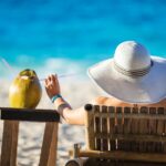 young-woman-sunbathing-and-drinking-coconut-juice