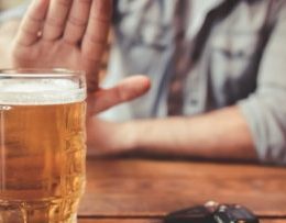 Man declining a beer on the table.