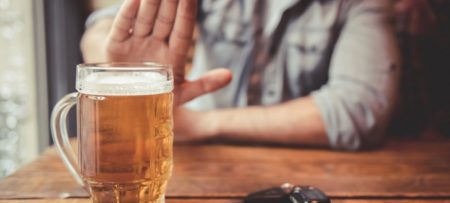 Man declining a beer on the table.