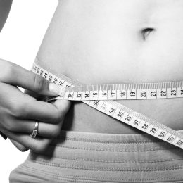 Woman measuring her waist.