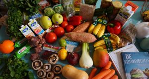 Table wwith variet of fruits, vegetables, and mushrooms, among other healthy foods.